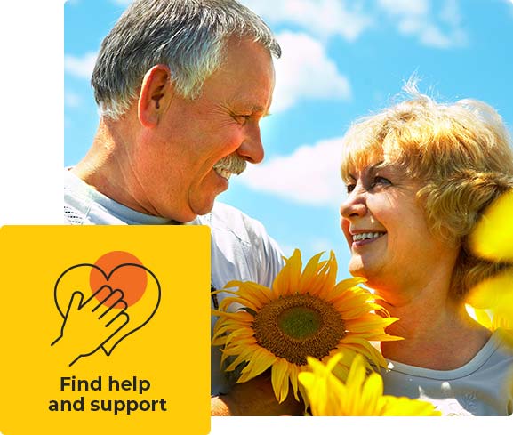 A couple looking at each other holding a sunflower